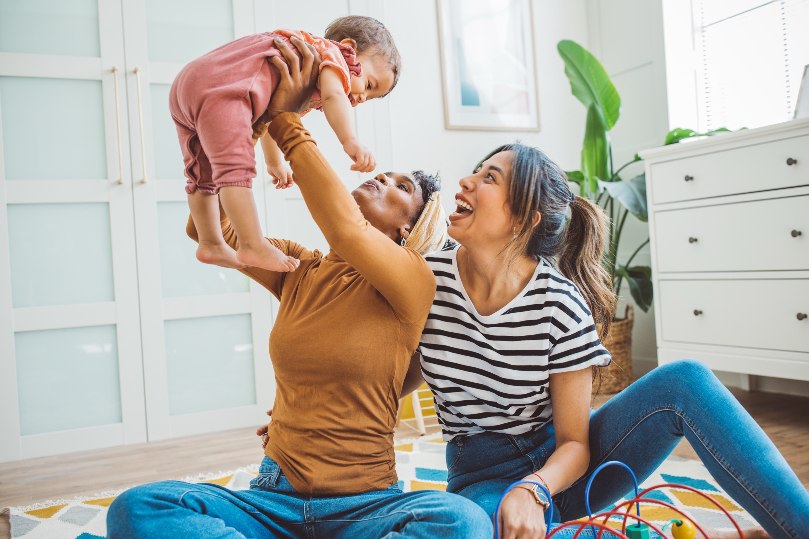 Two mothers holding a baby